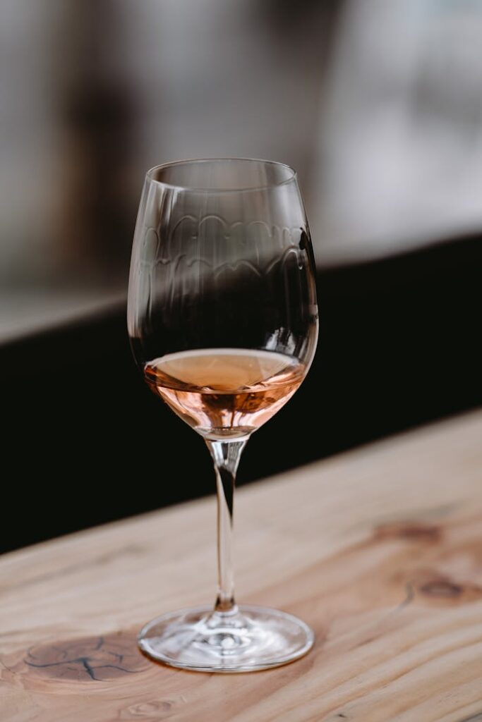 pexels photo 4913370 High angle of elegant crystal glass of aromatic rose wine served on wooden table in restaurant