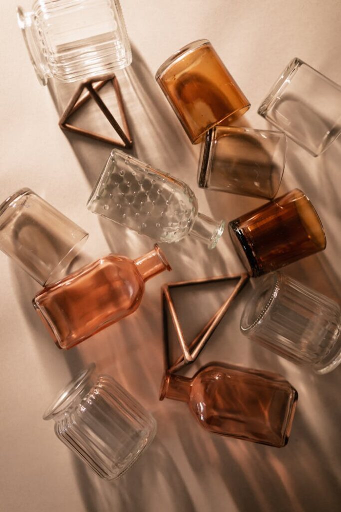 pexels photo 7222213 A creative arrangement of clear and amber glass bottles on a warm background.