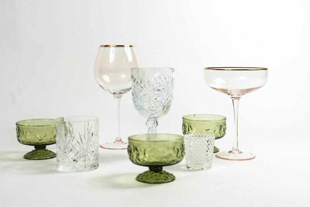 pexels photo 7809795 Collection of various empty colorful glasses with different shapes for different drinks placed on floor in light studio on white background